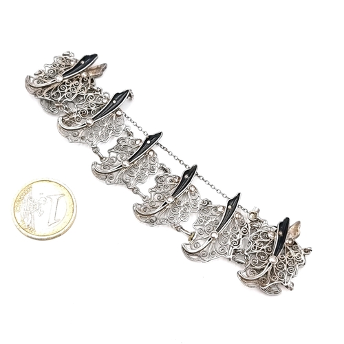 35 - A Siamese sterling silver filigree bracelet with attractive stone accents. Set with safety chain. We... 