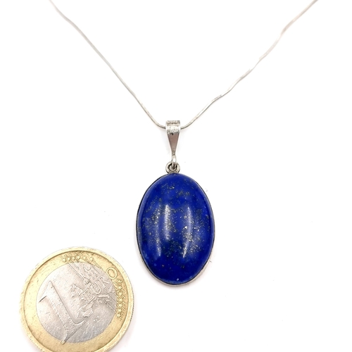 54 - A lovely large Lapis Lazuli oval cabochon pendant set with silver chain. Length of chain - 44 cms. W... 