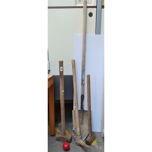 352 - Two sledge hammers of different weights, a pick axe along with a shovel.