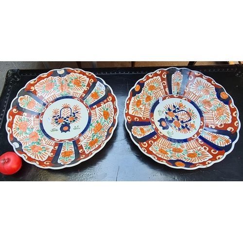 391 - Star lot : A pair of very large antique ceramic hand painted japenese imari chargers in red, orange ... 