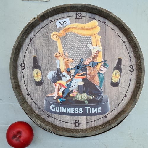 398 - A wooden wall clock advertising Guinness in the form of a barrel top.