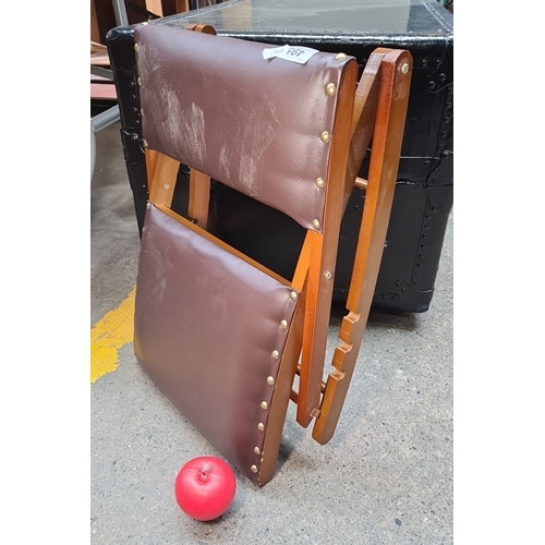 495 - A folding wooden kneeling stool with brown vinyl upholstery and brass rivets.