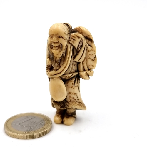 507 - A super fine bone carved antique Netsuke (two halves) figure of a man carrying his possessions set w... 