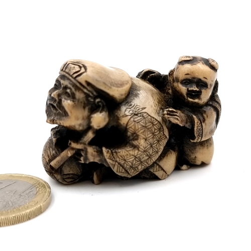 509 - A carved dual figure Netsuke (two holes) depicting a man & child. Dimensions - 5 x 3 cms. Weight - 3... 