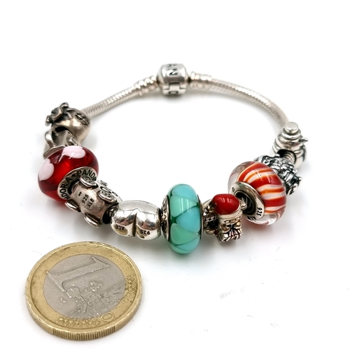 538 - A sterling silver Pandora bracelet with eleven 925 charms. Comes in original Pandora box. Weight of ... 