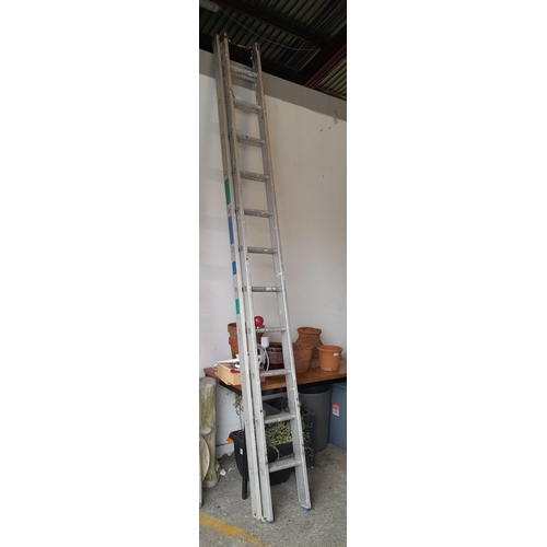 1034 - A tall 11 rung extending aluminium ladder.