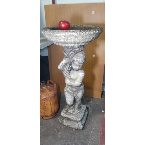 1040 - Star Lot: A vintage heavy reconstituted stone birdbath featuring a cherub holding up a round basin. ... 