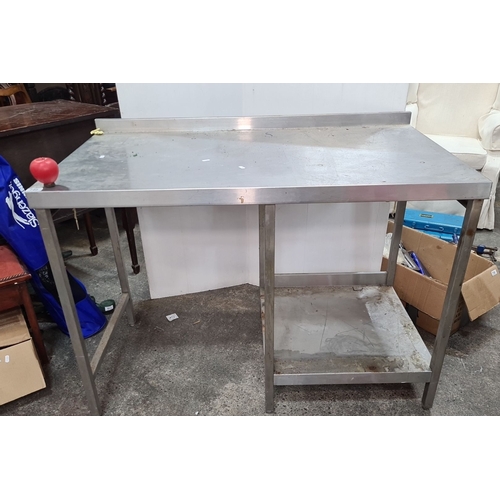 740 - Stainless steel work table with backsplash. Features an under-shelf for additional storage.