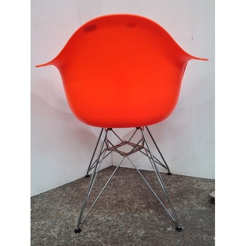 744 - A new Mid-Century Modern style orange molded plastic armchair with metal Eiffel base.