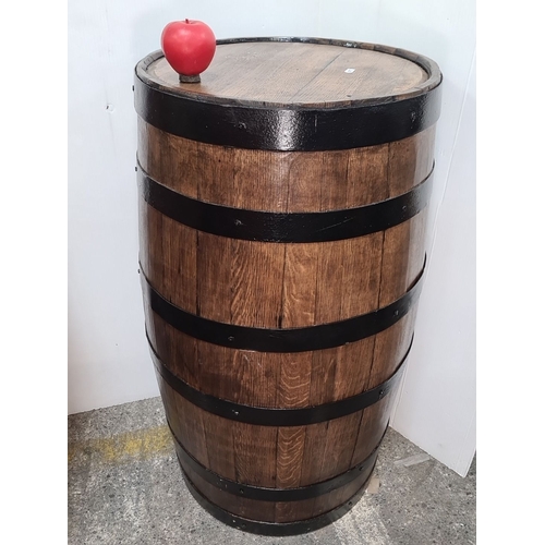 754 - Star Lot : A large Rustic wooden barrel with a wooden top and enhanced with black metal bands. It is... 