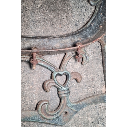 771 - Pair of cast iron antique have ornate bench ends featuring intricate scrollwork and heart motifs.