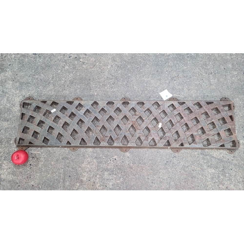 772 - A vintage cast iron grate with a latticed pattern, featuring mounting holes. Bench back.