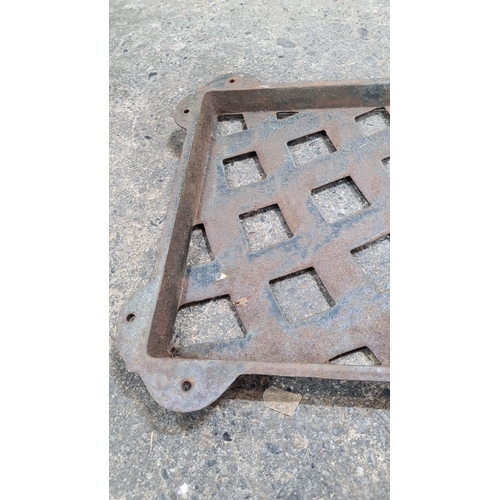 772 - A vintage cast iron grate with a latticed pattern, featuring mounting holes. Bench back.