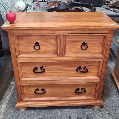 778 - Pinewood four-drawer chest with black metal handles. The chest has a rectangular top and a natural w... 