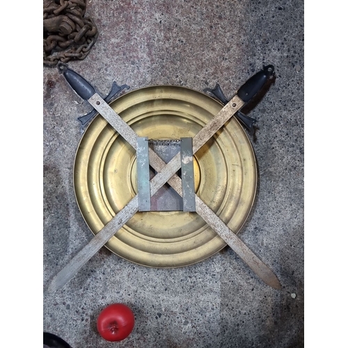 802 - Antique brass wall plaque with knight relief, featuring crossed swords as decoration. Likely from th... 