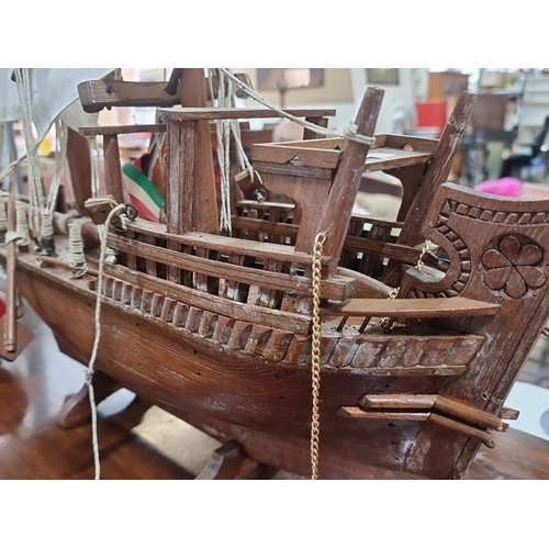 811 - A large vintage handcrafted wooden model ship with intricate detailing and cloth sails. Notable wood... 