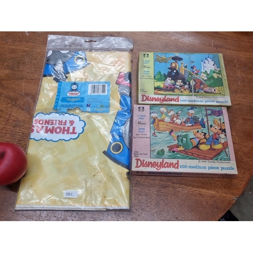 862 - The lot includes two 100-piece Disneyland puzzles by Tower Press, specifically the Mickey Mouse Trai... 