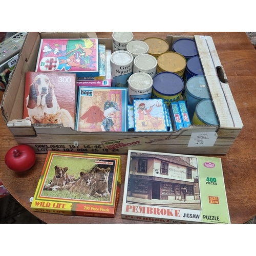 885 - A large box containing a mixed lot of vintage jigsaw puzzles, including pieces from various themes r... 