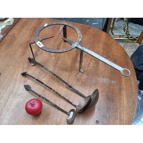 892 - An antique blacksmith-forged iron trivet and 3 blacksmiths ladles, with twisted handles and hammered... 