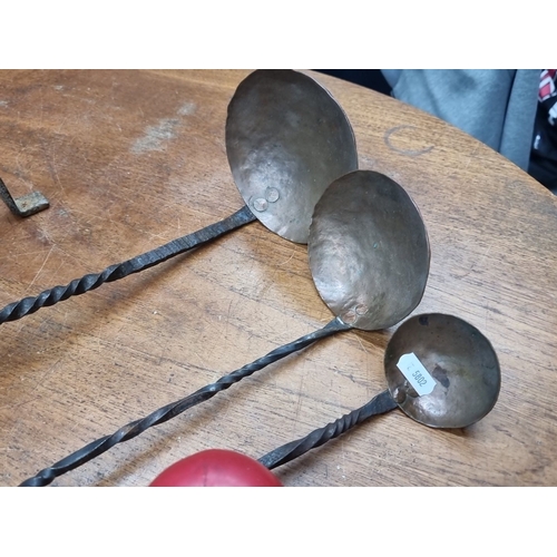 892 - An antique blacksmith-forged iron trivet and 3 blacksmiths ladles, with twisted handles and hammered... 