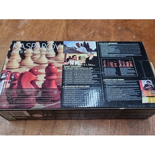 893 - A Kasparov Wood Chess Set. Finely crafted chess pieces and a folding wooden board. Includes a chess ... 