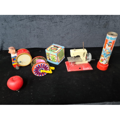 933 - A sweet assortment of vintage children's tin toys including a mechanical drummer and a mini sewing m... 