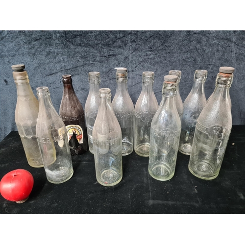 950 - A large red crate containing an assortment of vintage glass mineral bottles. Including some Newry ex... 