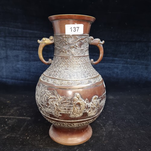 137 - Star Lot : A striking antique Japanese bronze and brass vase intricately carved with double handles.