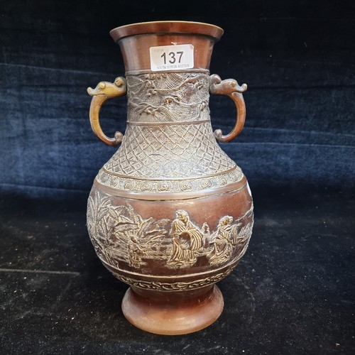 137 - Star Lot : A striking antique Japanese bronze and brass vase intricately carved with double handles.