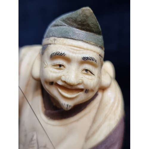 163 - Star Lot : A fabulous antique Japanese carved bone figure of a fisherman, displaying his catch, Supe... 