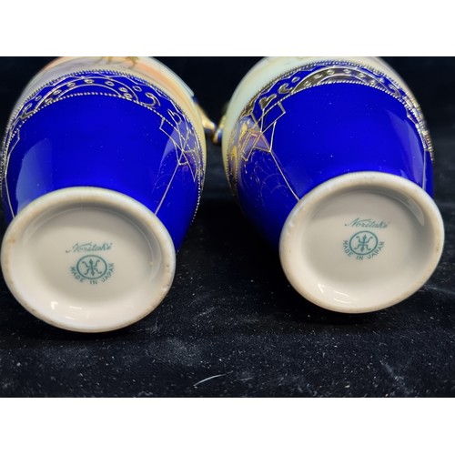 178 - A gorgeous pair of vintage  Noritake double handled bud vases featuring desert scenes, raised on a c... 