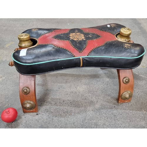 865 - Star Lot: An antique Brass Footstool stand with leather upholstery. Features red and black geometric... 