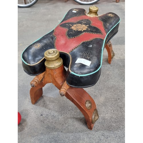 865 - Star Lot: An antique Brass Footstool stand with leather upholstery. Features red and black geometric... 