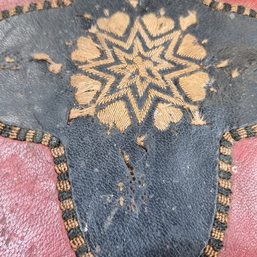 865 - Star Lot: An antique Brass Footstool stand with leather upholstery. Features red and black geometric... 