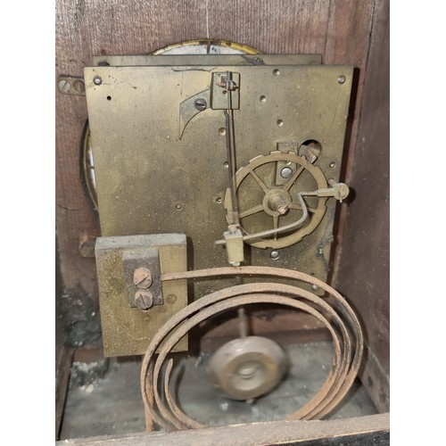 197 - An antique eight day walnut mantle clock featuring enamel face and Roman numeral dial. Nice example.