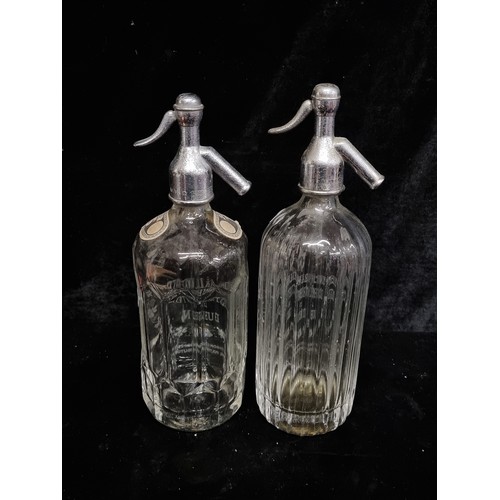 258 - Two vintage flying harp, glass soda syphons etched 'Mineral Waters Distributors LTD Dublin. One with... 