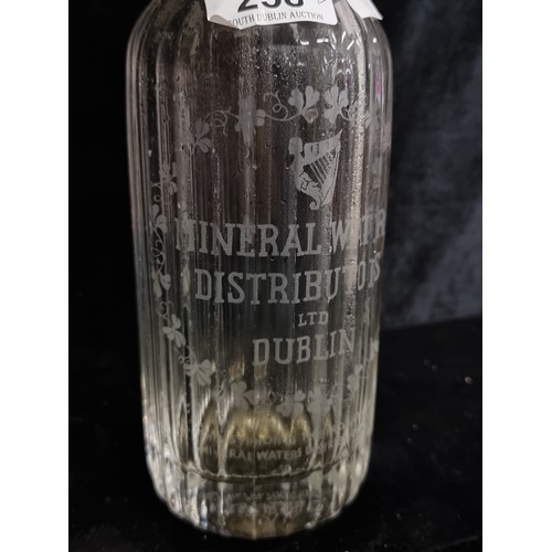 258 - Two vintage flying harp, glass soda syphons etched 'Mineral Waters Distributors LTD Dublin. One with... 