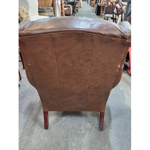 387 - A comfortable wing backed armchair in brown leather. Looks comfy. From a very fine home in Templemor... 