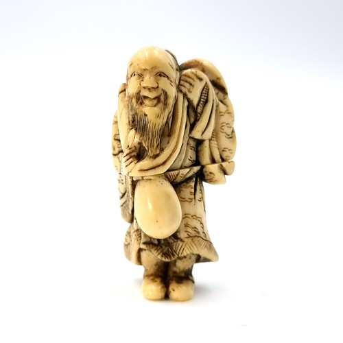 507 - A super fine bone carved antique Netsuke (two halves) figure of a man carrying his possessions set w... 