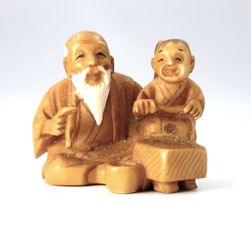 512 - An antique original Japanese  carved Netsuke figure (two holes) depicting an elderly seated man with... 