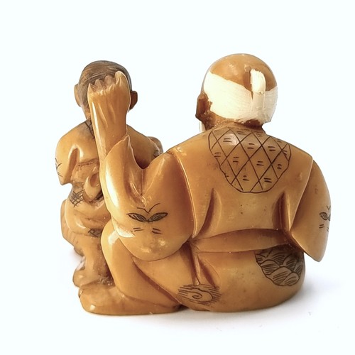 512 - An antique original Japanese  carved Netsuke figure (two holes) depicting an elderly seated man with... 