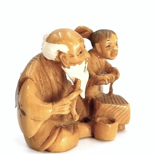 512 - An antique original Japanese  carved Netsuke figure (two holes) depicting an elderly seated man with... 