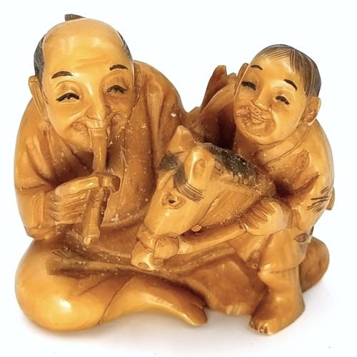 517 - An unusual Japanese original antique bone carved Netsuke (two holes) depicting two figures - one rid... 