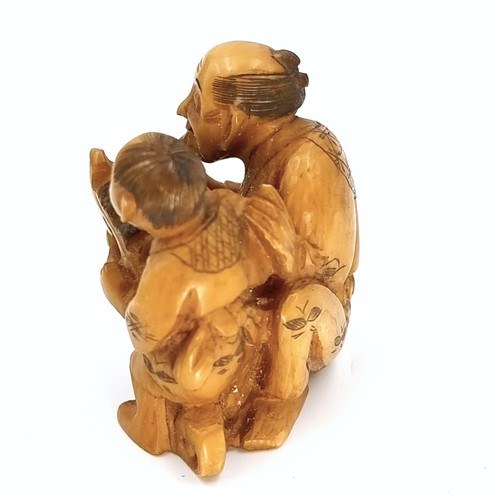 517 - An unusual Japanese original antique bone carved Netsuke (two holes) depicting two figures - one rid... 