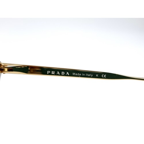 548 - A pair of as new Prada sunglasses made in Italy with reference details to stems. Comes with original... 