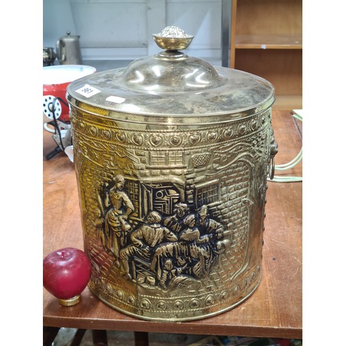 961 - A nicely size embossed brass lidded coal bin with drop leaf handles on either side.