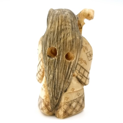 1063 - An antique carved bone Japanese netsuke with two holes for a toggle attachment with artist signature... 