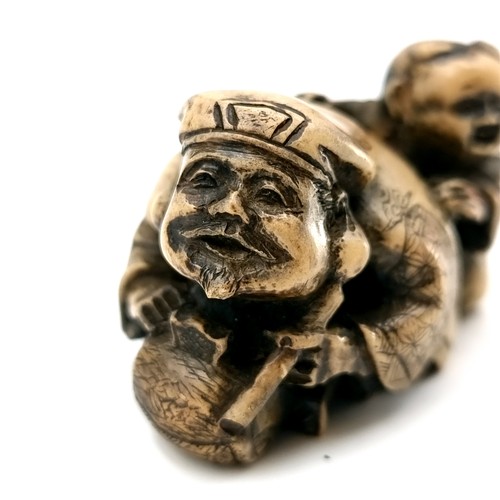 509 - A carved dual figure Netsuke (two holes) depicting a man & child. Dimensions - 5 x 3 cms. Weight - 3... 