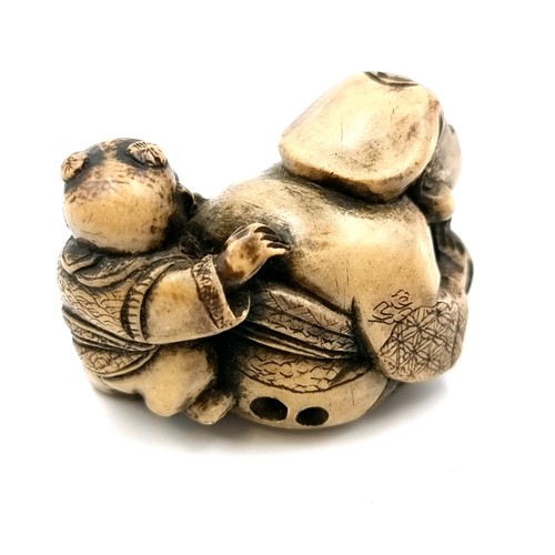 509 - A carved dual figure Netsuke (two holes) depicting a man & child. Dimensions - 5 x 3 cms. Weight - 3... 