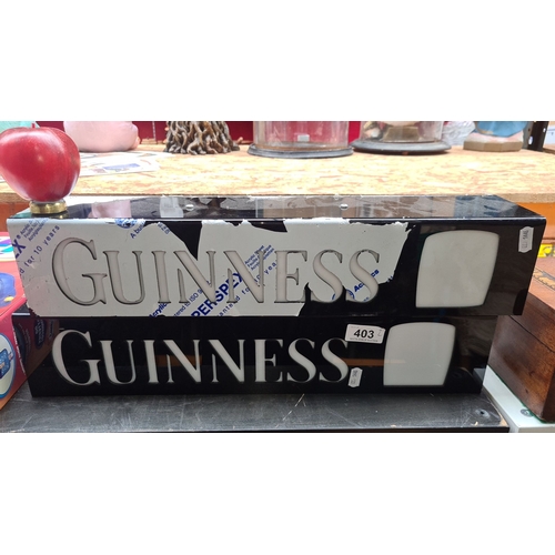 403 - Two Vintage Guinness illuminated bar sign, electric-powered with distinctive black and white design.